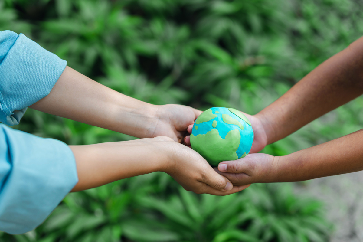 two people holding a globe green earth environmental conservatio